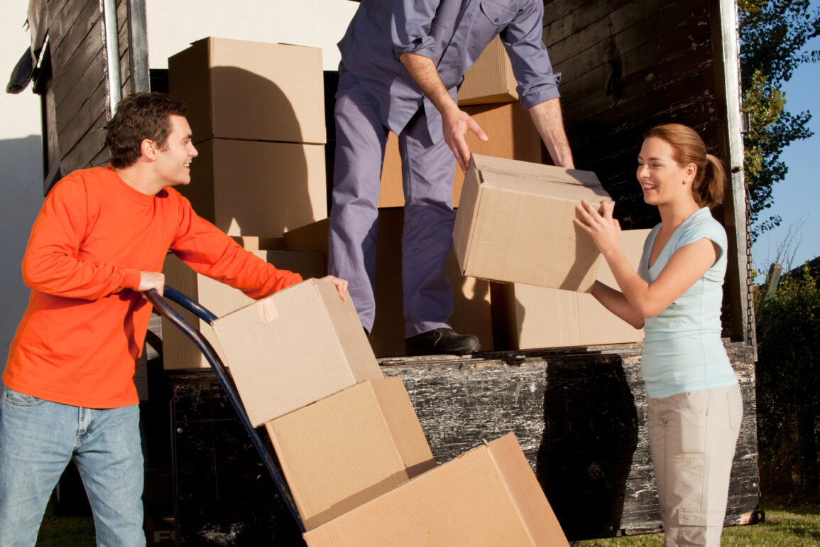 A group of people moving boxes from a trailer
